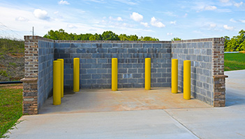 Image of a concrete dumpster enclosure for a front load trash bin.