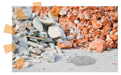 Concrete and brick debris lying on a construction site in two separate piles butting up against one another.