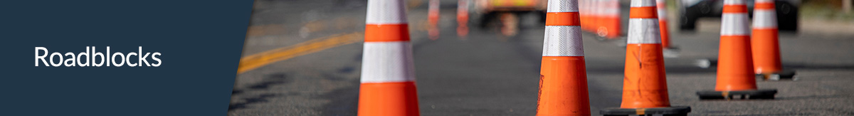 Orange traffic cones with white stripes blocking traffic on a jobsite.