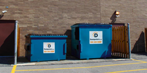 two front load dumpsters with a dumpster enclosure surrounding them