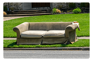 A couch near the street for curbside disposal.