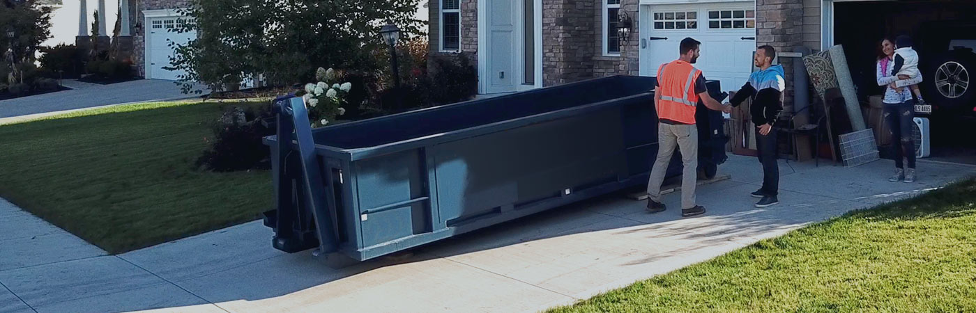 family thanking a driver for delivering a dumpster rental