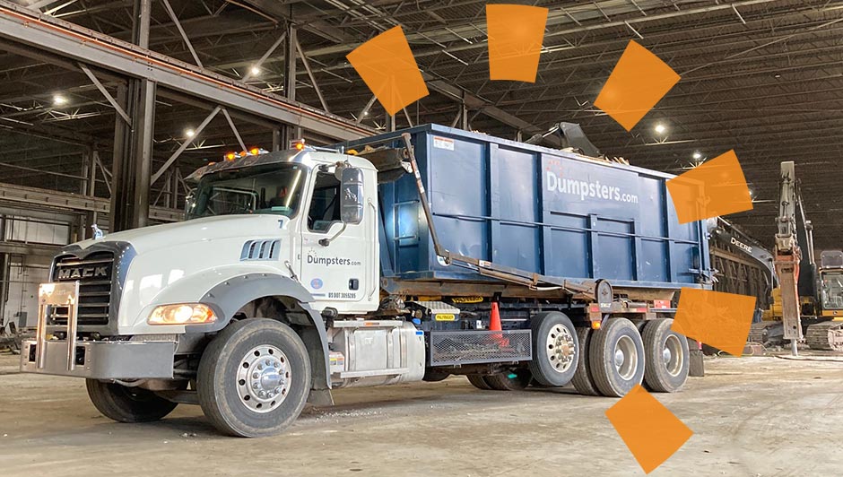 A Dumpsters.com dumpster and truck in a warehouse.