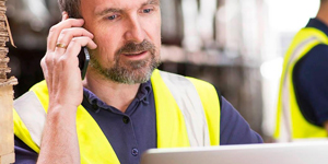 Man in Yellow Vest with Beard Talking on Phone