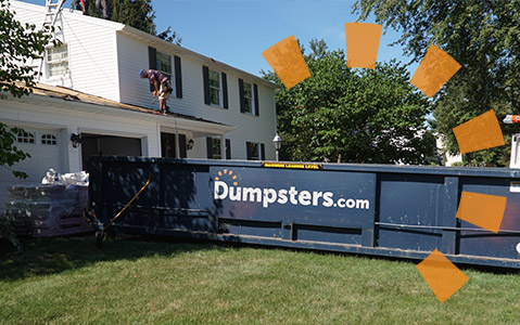 Dumpsters.com roll off dumpster on a driveway filled with roofing debris