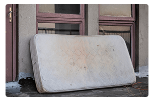 An old mattress leaning against a wall.