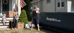 family loading a dumpster rental with trash